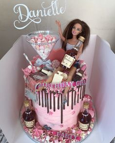 a barbie doll sitting on top of a pink cake covered in chocolate and marshmallows