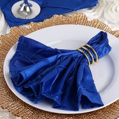 a white plate topped with blue napkins on top of a table