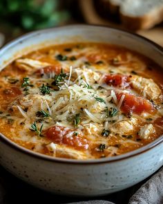 a bowl of soup with cheese and tomatoes