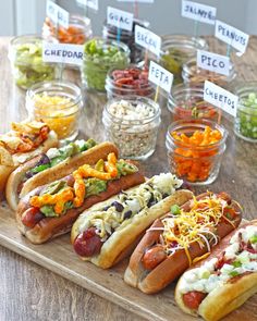 several hot dogs on buns with condiments and pickles