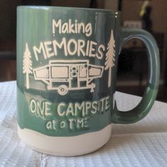 a green and white coffee mug with the words making memories one campsite at a time