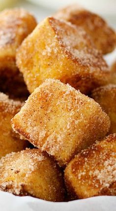 some sugar cubes are in a white bowl on a table with other food items