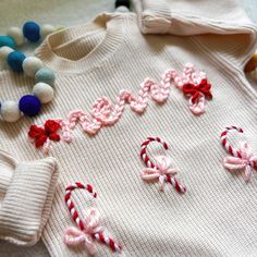 a sweater with candy canes on it and the word happy spelled out in letters