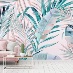 a living room with pink and blue wallpaper, palm leaves on the wall and a coffee table