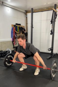 a man is squatting down with a barbell