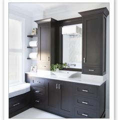 a bathroom with two sinks and cabinets in it