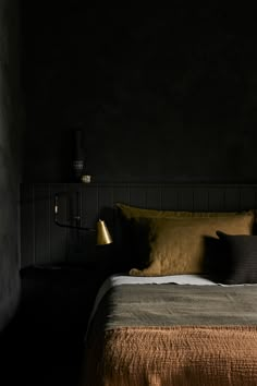 a bed in a dark room with two lamps on either side