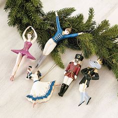 some figurines are hanging from a christmas tree