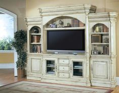 a large entertainment center with bookshelves and tv on it's stand in a living room