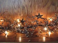 a wooden shelf topped with lots of lights and branches covered in star shaped decorations on top of it