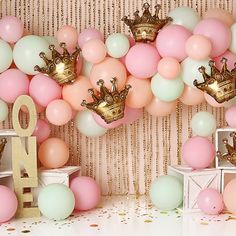 there are balloons and gold crowns on the wall