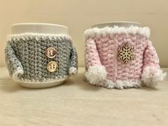 two crocheted mug cozyies sitting next to each other on top of a table