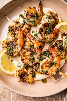 grilled shrimp skewers with lemon wedges on a plate