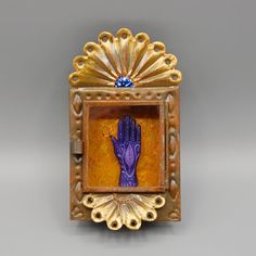 an ornate gold frame with a hand painted on it