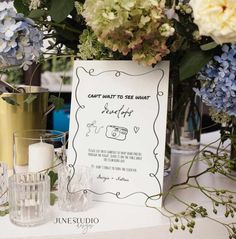 a table topped with vases filled with blue and white flowers next to a sign that says can't wait to see what is empty