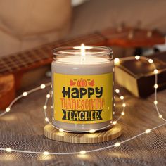 a candle that says die hard is a christmas movie on it next to a guitar