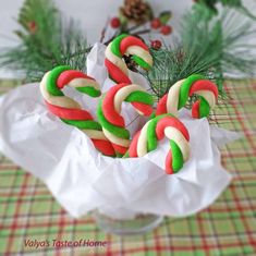 some candy canes are in a glass vase