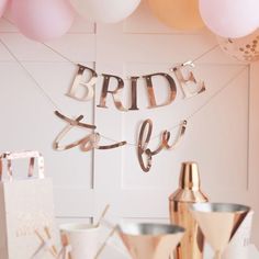 the bride to be table is set up with pink balloons and gold confetti