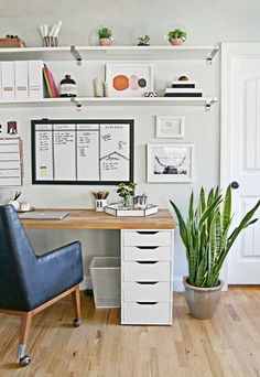 a home office with white walls and wooden floors