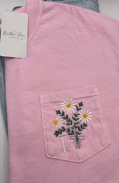 a pink shirt with daisies in the pocket