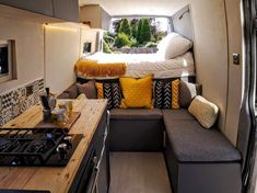 the interior of a camper with a couch and kitchenette in it, as well as a bed