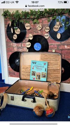 an open suitcase sitting on top of a blue carpeted floor next to record players