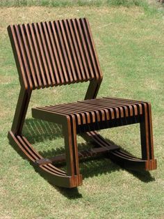 a wooden chair sitting on top of a lush green field