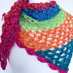 a multicolored crocheted scarf on a mannequin