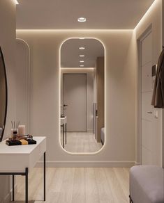 a bathroom with a mirror and lights on the wall, along with a bench in front of it