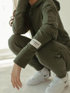 The classic Cropped Hoodie - a sage green staple, designed with a flattering boxy silhouette and slight dropped shoulder in a mid-weight cotton that's comfortable, soft and perfect for layering.  Features rib-knit cuffs, a drawstring hood, and embroidery detailing. Plus, the raw edge hem means you can crop it to your desired length.   10% of proceeds benefit female forward charities giving back to women through the  provision of resources and opportunities. Machine wash cold. Tumble dry low heat Green Tops With Side Pockets For Fall, Green Athleisure Outerwear With Ribbed Cuffs, Green Sweatshirt With Pockets For Loungewear, Oversized Khaki Hoodie With Ribbed Cuffs, Sporty Khaki Hoodie With Ribbed Cuffs, Green Sweatshirt With Ribbed Cuffs For Everyday, Green Relaxed Fit Outerwear With Drawstring Hood, Green Urban Top With Ribbed Cuffs, Urban Green Tops With Ribbed Cuffs