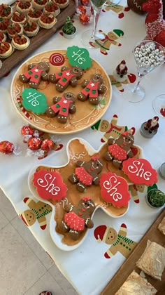 gingerbreads and cookies are on display at a christmas themed table with other desserts