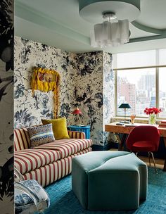 a living room filled with furniture and walls covered in floral wallpaper next to a window