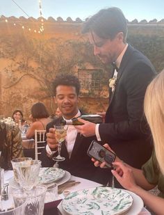 a group of people sitting around a table with plates and drinks in front of them