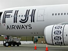 an airplane is parked on the tarmac with orange cones around it's feet