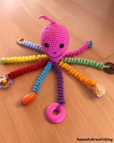 a crocheted octopus toy sitting on top of a wooden floor next to some toys