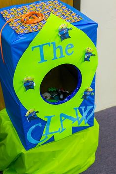 a green and blue cardboard box with the words the claw on it's side