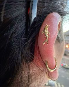 a close up of a persons ear with a lizard on it