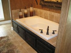 a bath tub with two faucets in the middle of a tiled floored bathroom