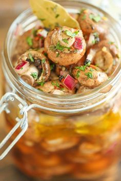 a glass jar filled with pickled mushrooms and vegetables