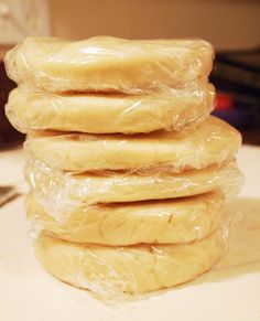 a stack of doughnuts wrapped in plastic sitting on top of a white counter