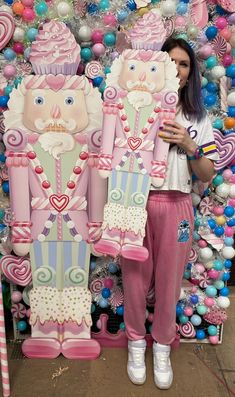 a woman standing in front of giant candy decorations