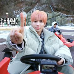 a man sitting on top of a red motorcycle giving the peace sign with his hand