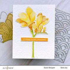 a close up of a card with a flower on it and an envelope in the background