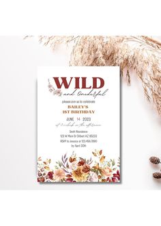 a wild birthday party card with flowers and feathers on it, next to pine cones