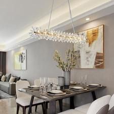 a dining room table with white chairs and a chandelier hanging from the ceiling