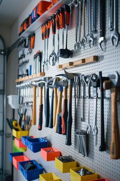 a peg board filled with lots of tools on top of a wall next to bins