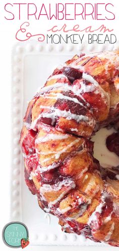 a close up of a doughnut on a plate with icing and strawberries