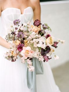 a bride holding a bouquet of flowers in her hand