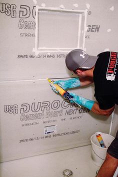 a man is painting the wall in his bathroom