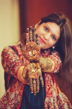 a woman holding up her hands with henna designs on it's palms and arms